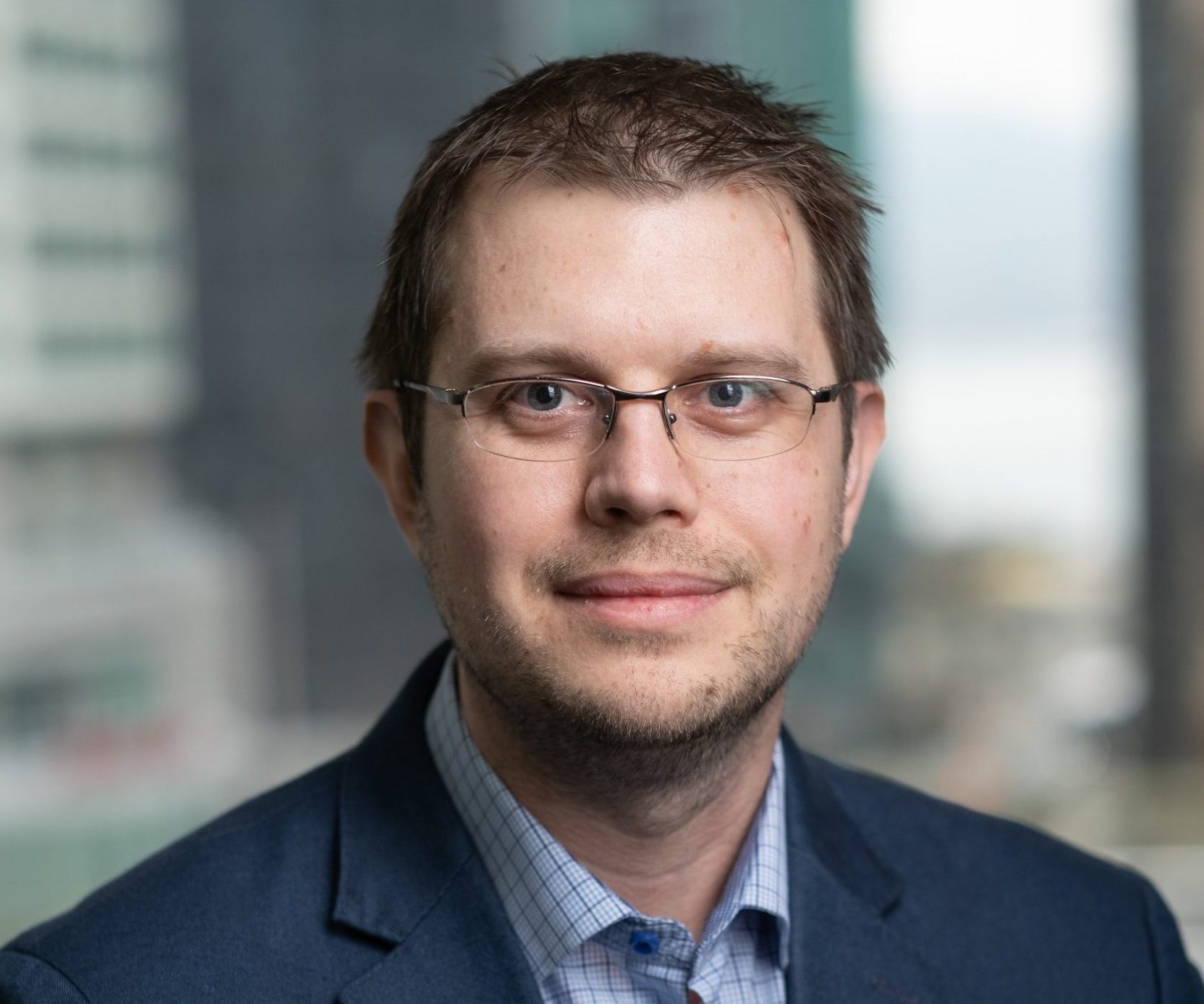 Headshot of president of Gravit-e, Nick Oostveen who is wearing a suit.