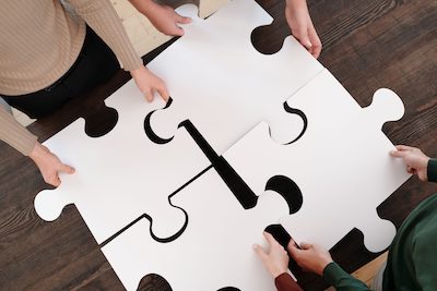 Giant puzzle pieces put together by four people