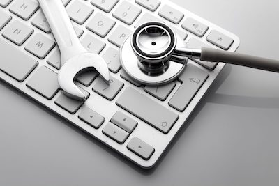 Keyboard with stethoscope and wrench on top